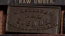 アンティークの水彩絵具箱に並ぶ「RAW SIENNA」のケーキ絵具
